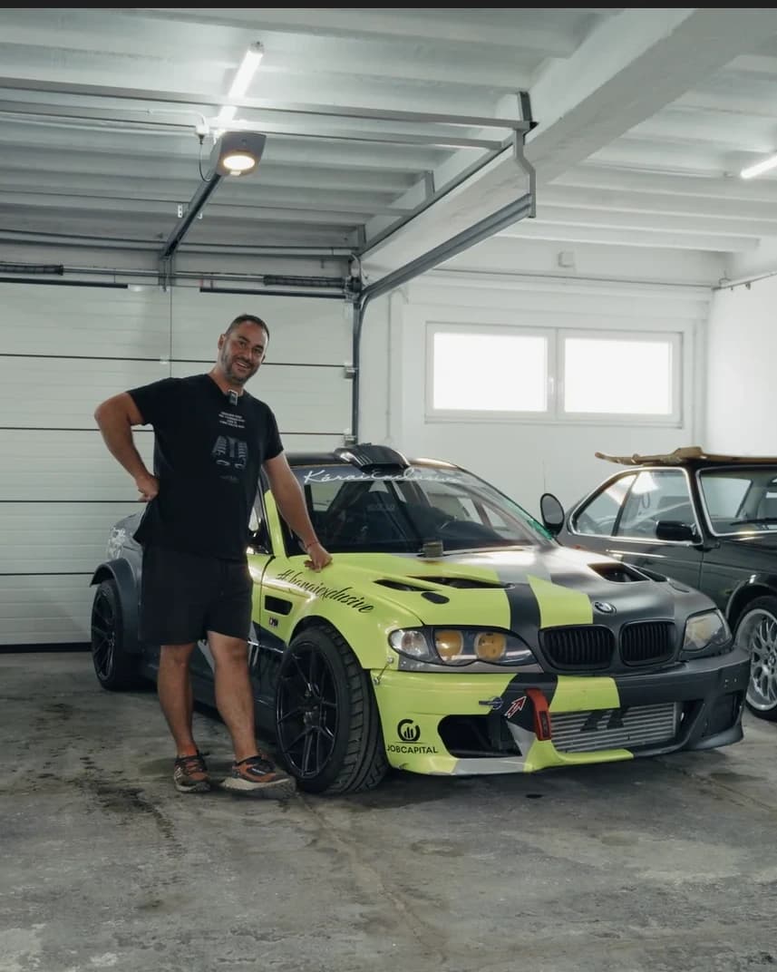 Kárai Exclusive presenter standing beside a modified BMW in the workshop