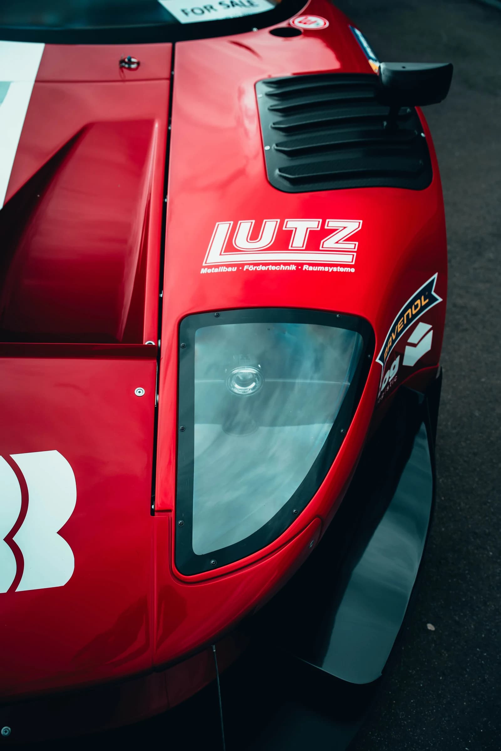 Close detail of a red race-inspired show car at Ultrace 2025