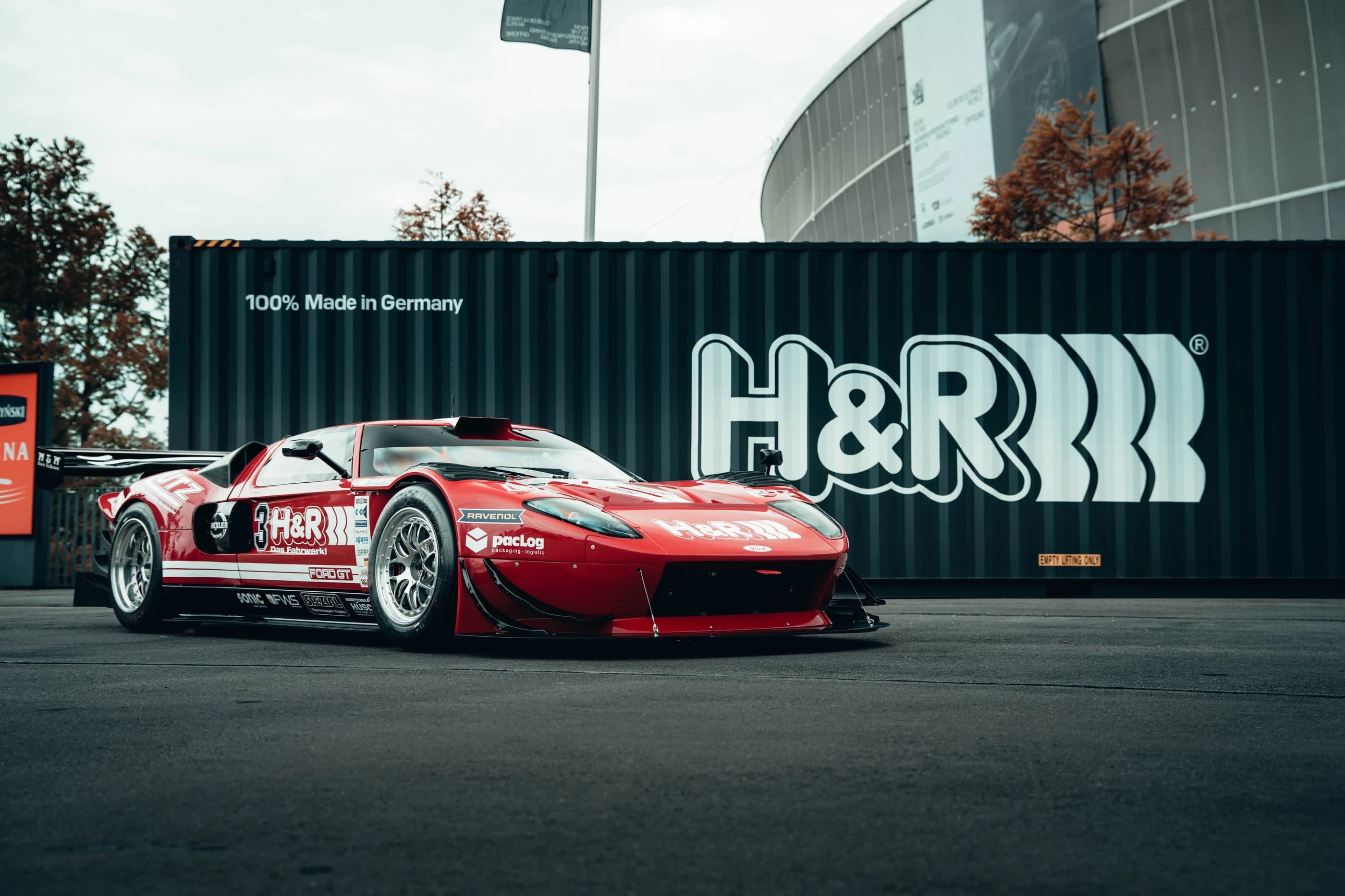 Red show car displayed beside H&R branding at Ultrace 2025 in Wrocław