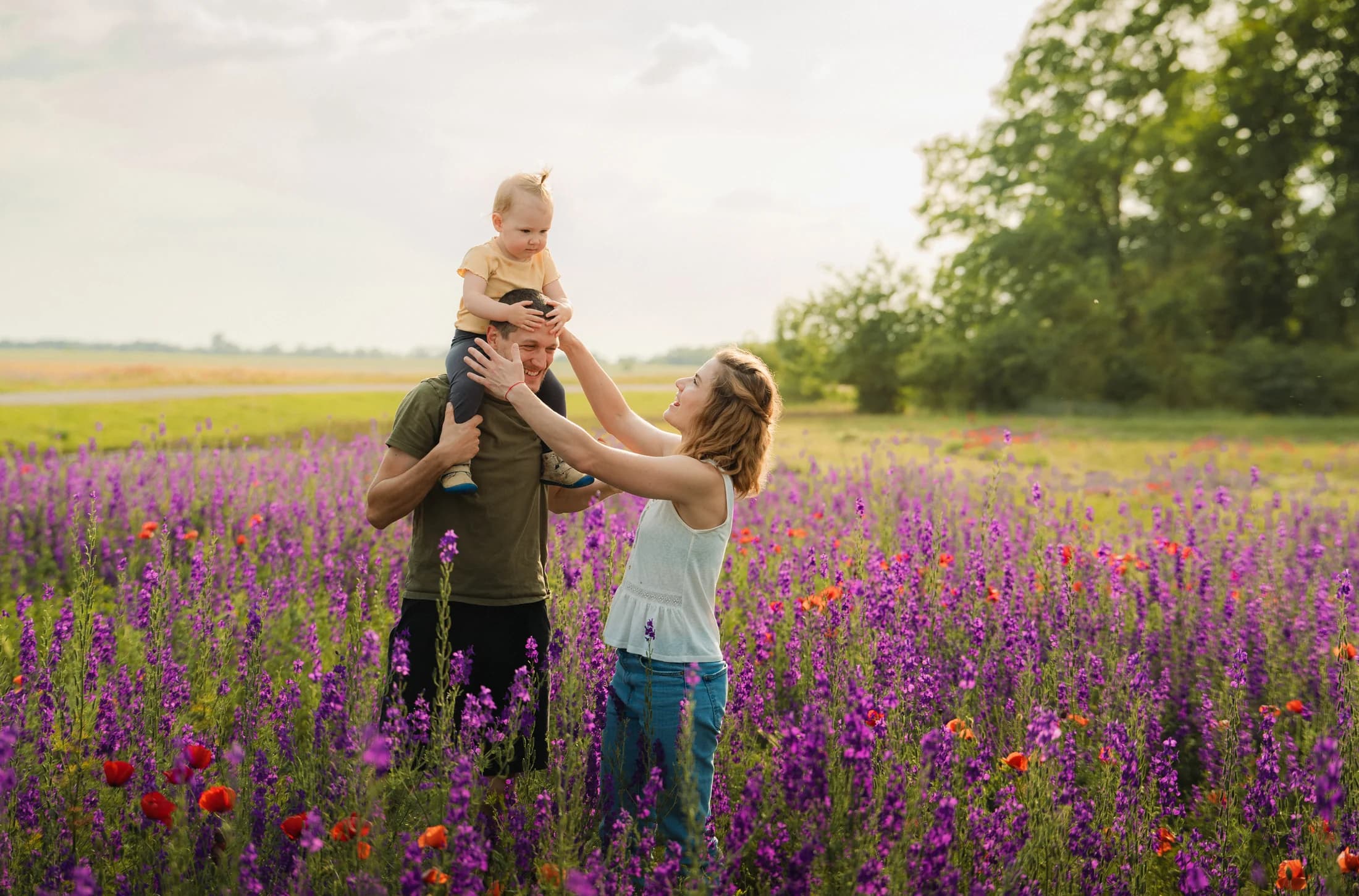 Mother lifting her child in a wildflower field