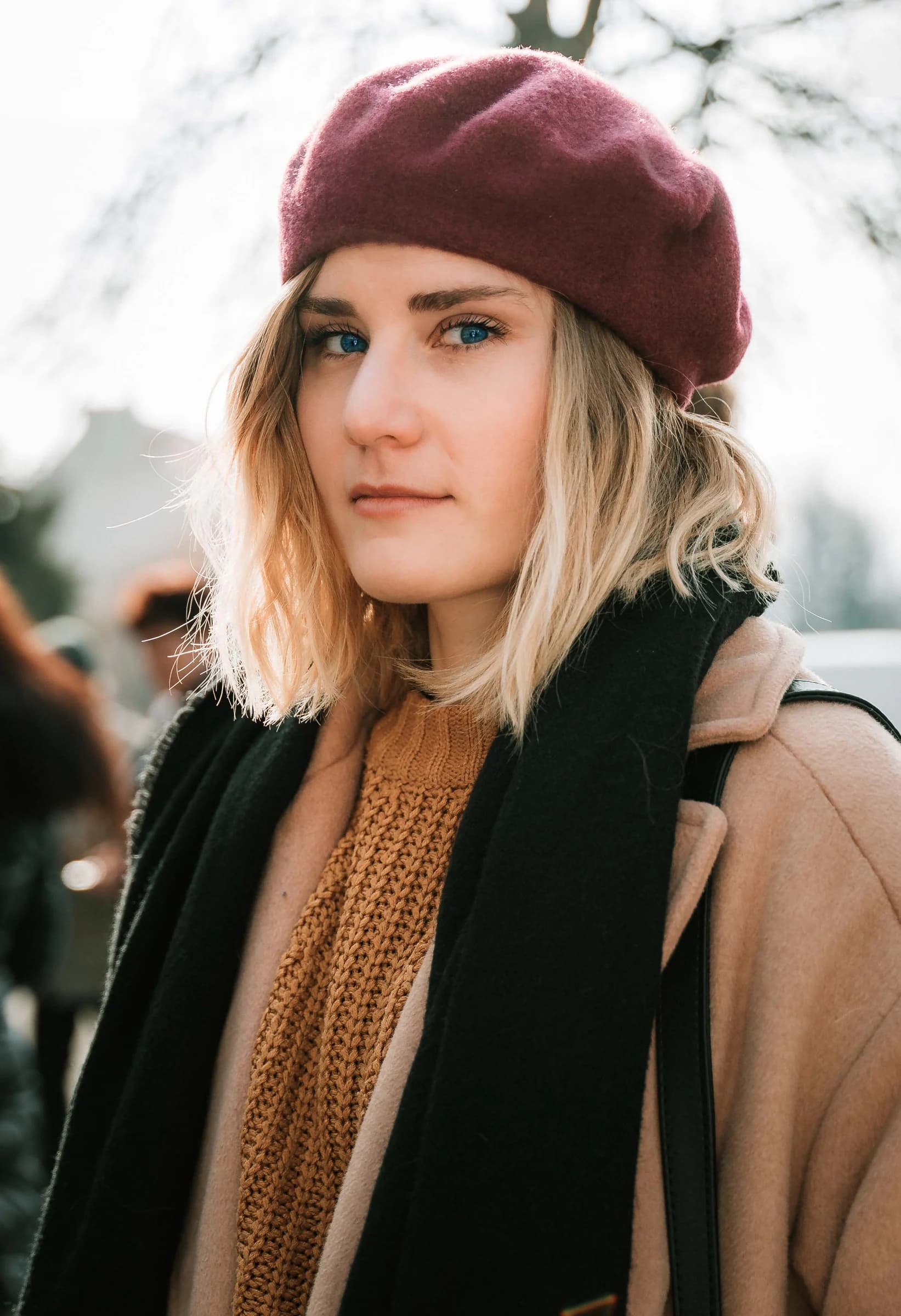 Outdoor portrait of a woman wearing a burgundy beret and scarf