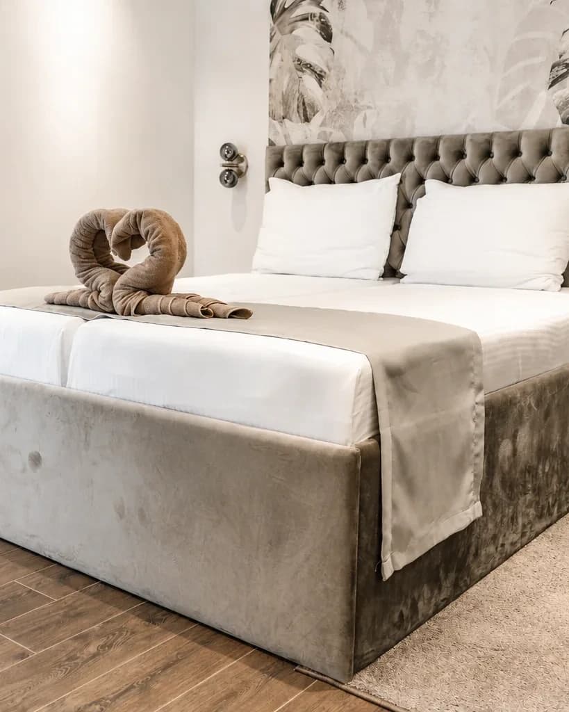 Bedroom at Merlin Apartments with a towel arrangement on the bed