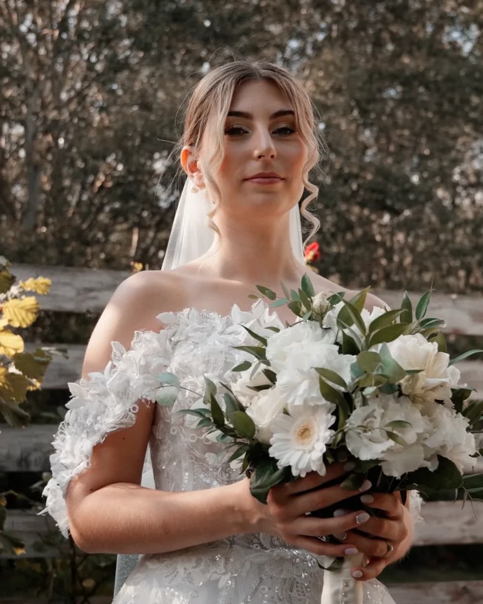 Portrait of Fanni holding her white bridal bouquet