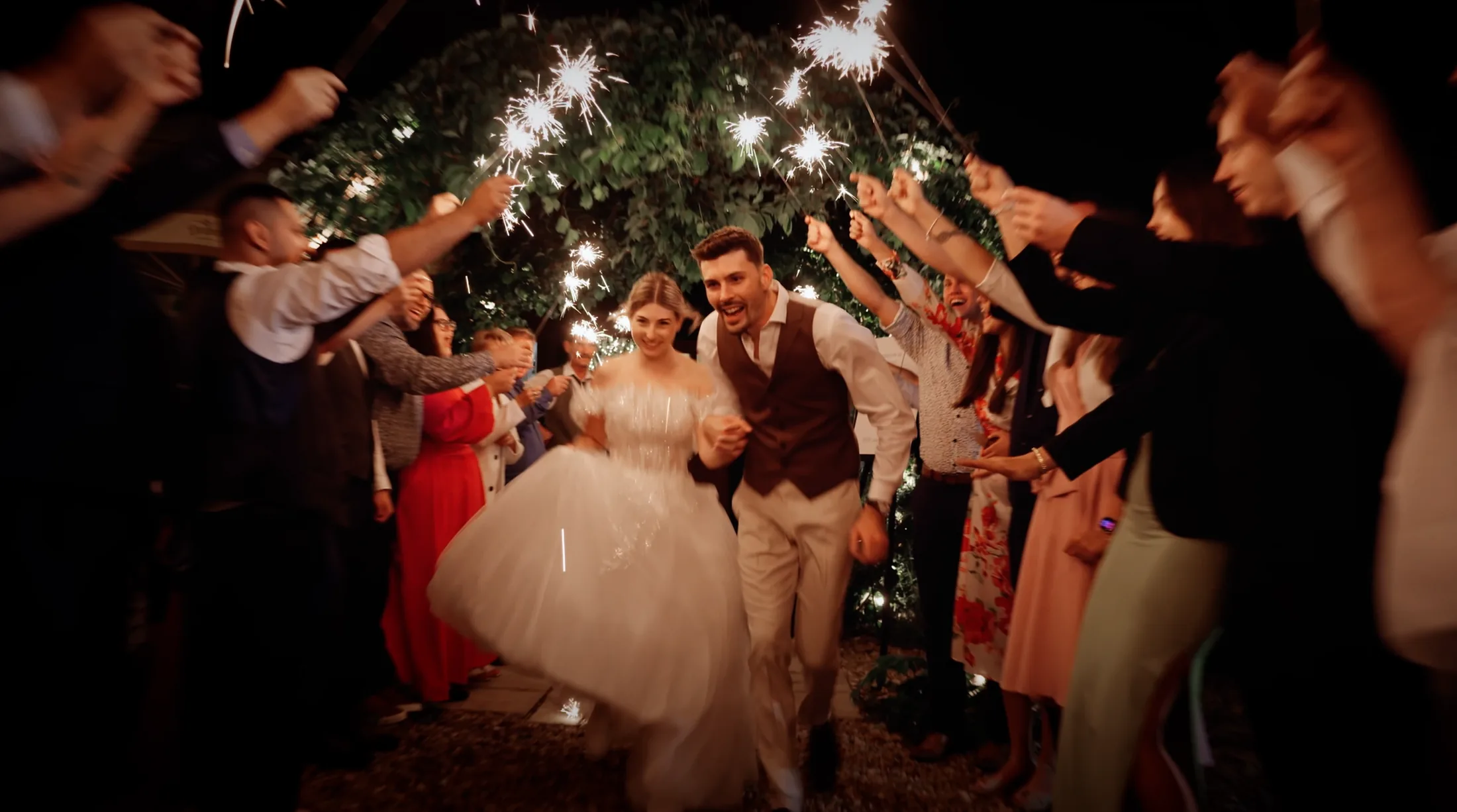Fanni and Kristóf walking through a sparkler send-off at the evening celebration